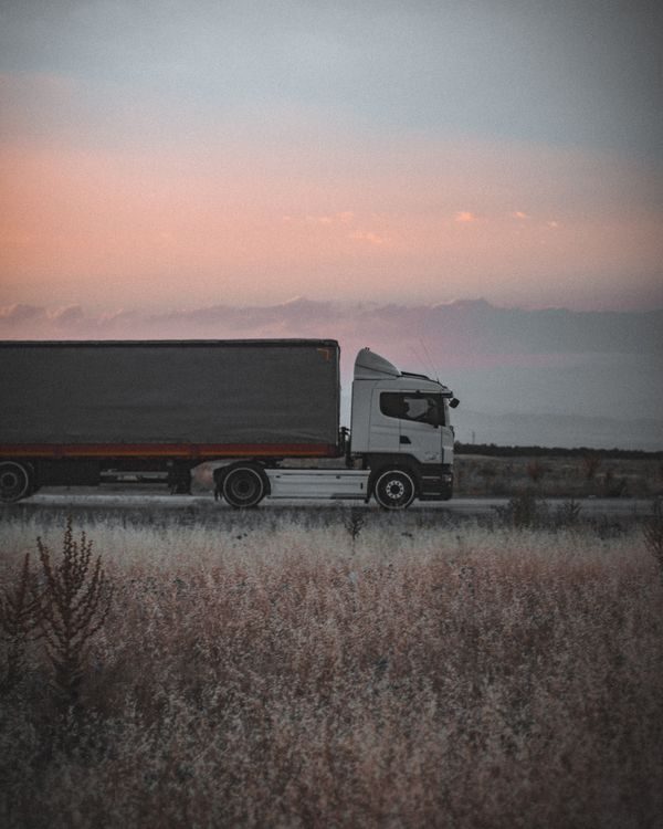 Semi truck driving on an interstate highway at sunset