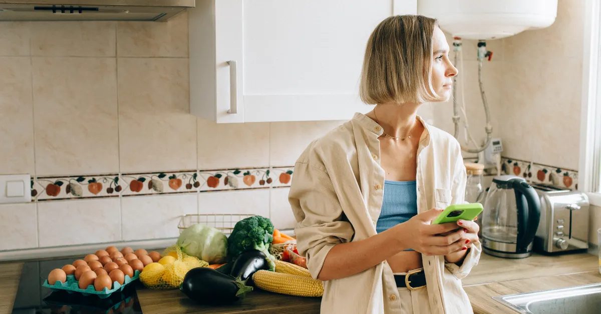 Woman at home checking the app on her phone